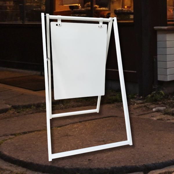 White a-frame sign on a sidewalk in front of restaurant