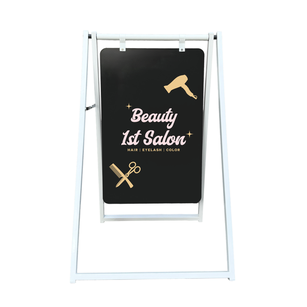 A-frame sign for Beauty 1st Salon with hair dryer and scissors graphics on a metal chalkboard
