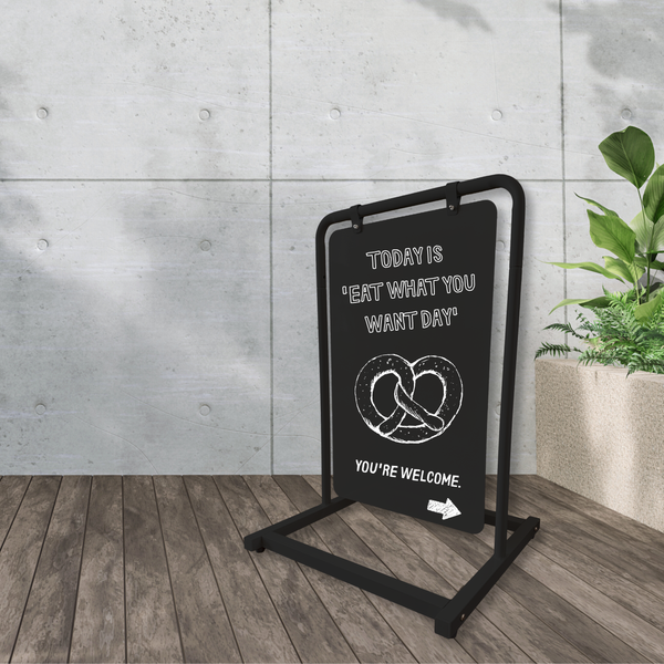 Black metal short swing sign with advertising promoting pretzel
