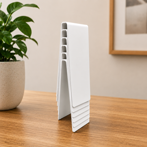 White table number sign stacking on a wooden table with a plant in the background