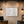 Hanging Menu board with options for cookies and cakes on a wall with lighting fixtures on the sides.