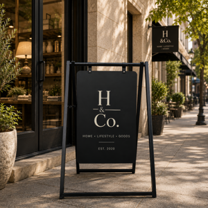 A-frame sign for H & Co. outside a store on a city street.