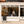 Storefront with glass window displaying interior and a business advertising sign outside.