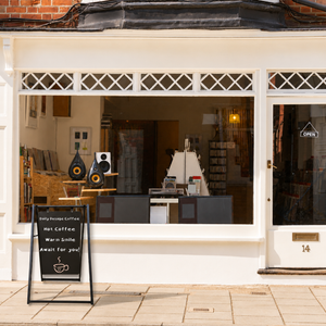 Storefront with glass window displaying interior and a business advertising sign outside.