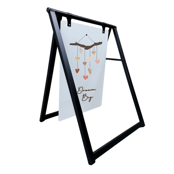 Black a-frame sign holder with a decorative card featuring heart designs and text.