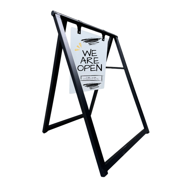 Black sidewalk metal sign holder with a 'WE ARE OPEN' white sign on a white background