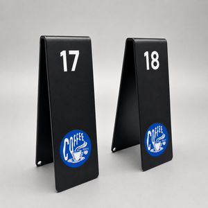 Two black table number signs with numbers and a coffee-themed logo on a gray background