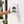 A white, semi-circular outdoor blade sign against a light beige stucco wall. The sign features a black icon of a family of five above the text 'FAMILY RESTROOM'.