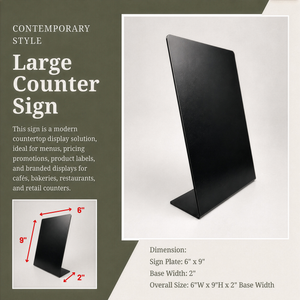 Large black metal countertop sign  shown on a light gray background with product text and dimension callouts. The left side includes descriptive marketing text, a smaller inset showing the sign angles, and dimensions: 6" x 9" plate, 2" base width, and overall 6" x 9" x 2" base width.