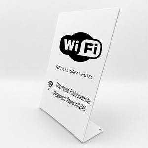 A white freestanding metal tabletop message sign with a black WiFi logo and sample login/password text