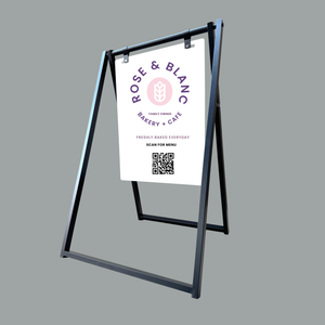A-frame sign with Rose & Blanc Bakery & Cafe logo on a gray background