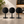 Three minimalist black round tabletop stands, arranged side by side on a light stone countertop in a softly lit interior setting.