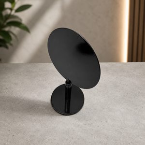 A minimalist black metal tabletop circular sign on a round stand from a top view. 