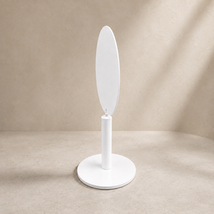 A minimalist white oval stand and round base, set against a warm beige textured background with soft diagonal shadows.
