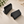 Stacks of black counter signs cards on a beige surface with a plant in the corner.