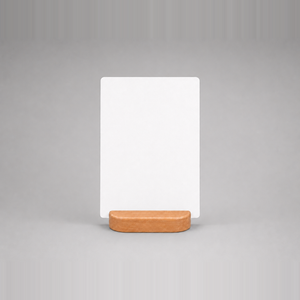 A minimalist tabletop sign insert sitting on a small rounded rectangular wooden base.