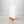 A minimalist white tabletop sign holder featuring a vertical white board sitting on a rounded rectangular wooden base.