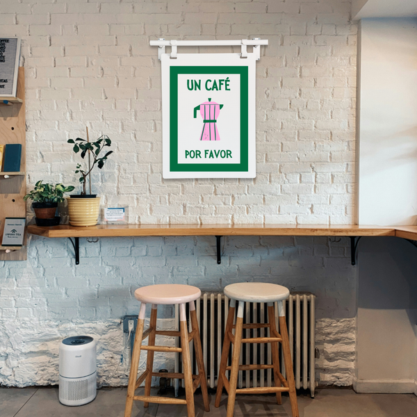 Wooden bar stools in front of a wall with a framed sign and plants.