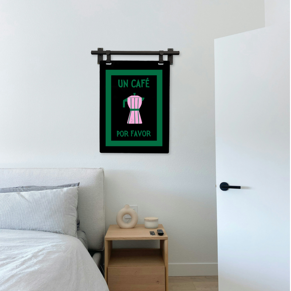 Framed artwork with text and a coffee maker icon on a wall above a bed.